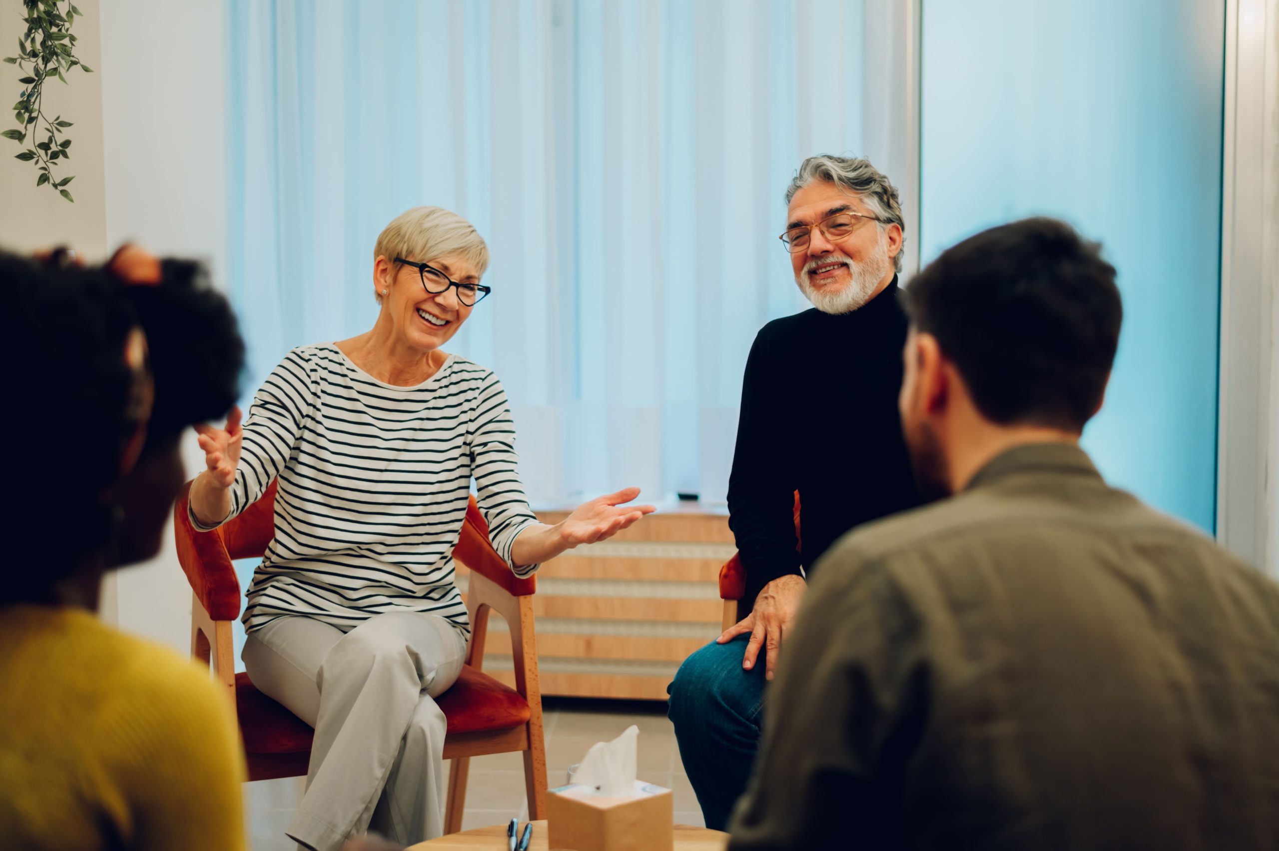 Servicios de integración social: sesión de grupo con una profesional y varias personas en círculo