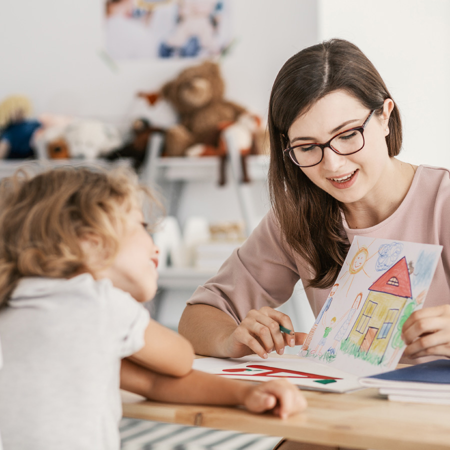 Profesional mostrando un dibujo a una niña durante una sesión de acompañamiento
